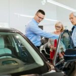 boomers shopping for a new car with salesman in a dealership