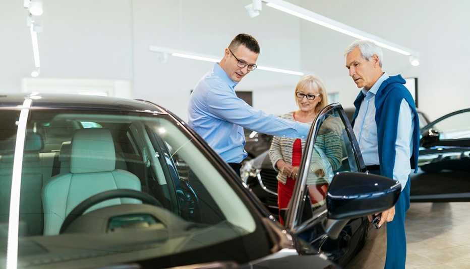 boomers shopping for a new car with salesman in a dealership