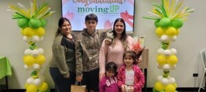 Naperville Cares Moving Up program graduation ceremony: Group photo of proud graduates celebrating their achievements and brighter futures.