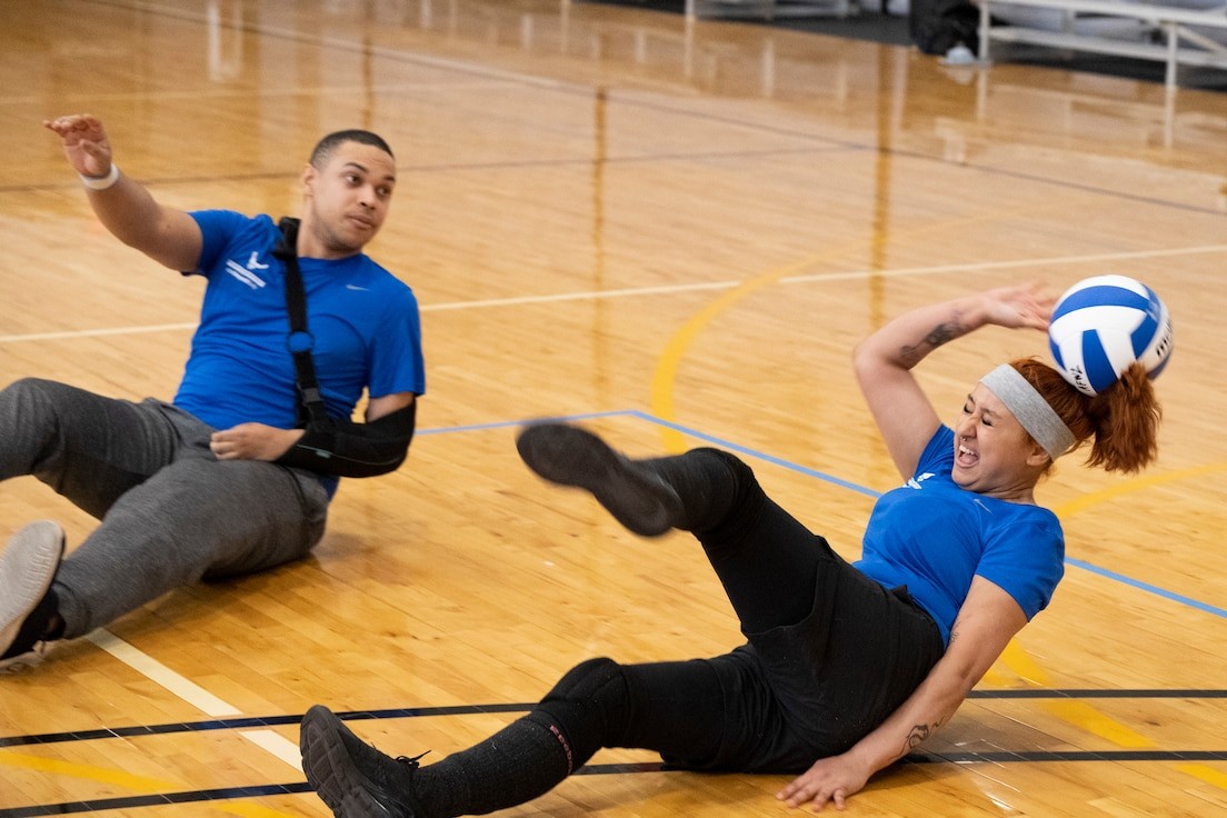 Soldiers engaging in a volleyball drill during adaptive sports training.