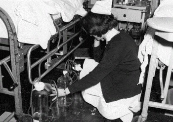 Nurse examining chest tube drainage bottles, Hospital of the University of Pennsylvania, 1972