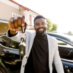 Smiling man holding car keys, representing successful car key programming.