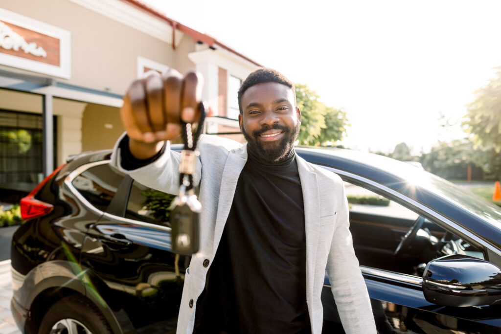 Smiling man holding car keys, representing successful car key programming.