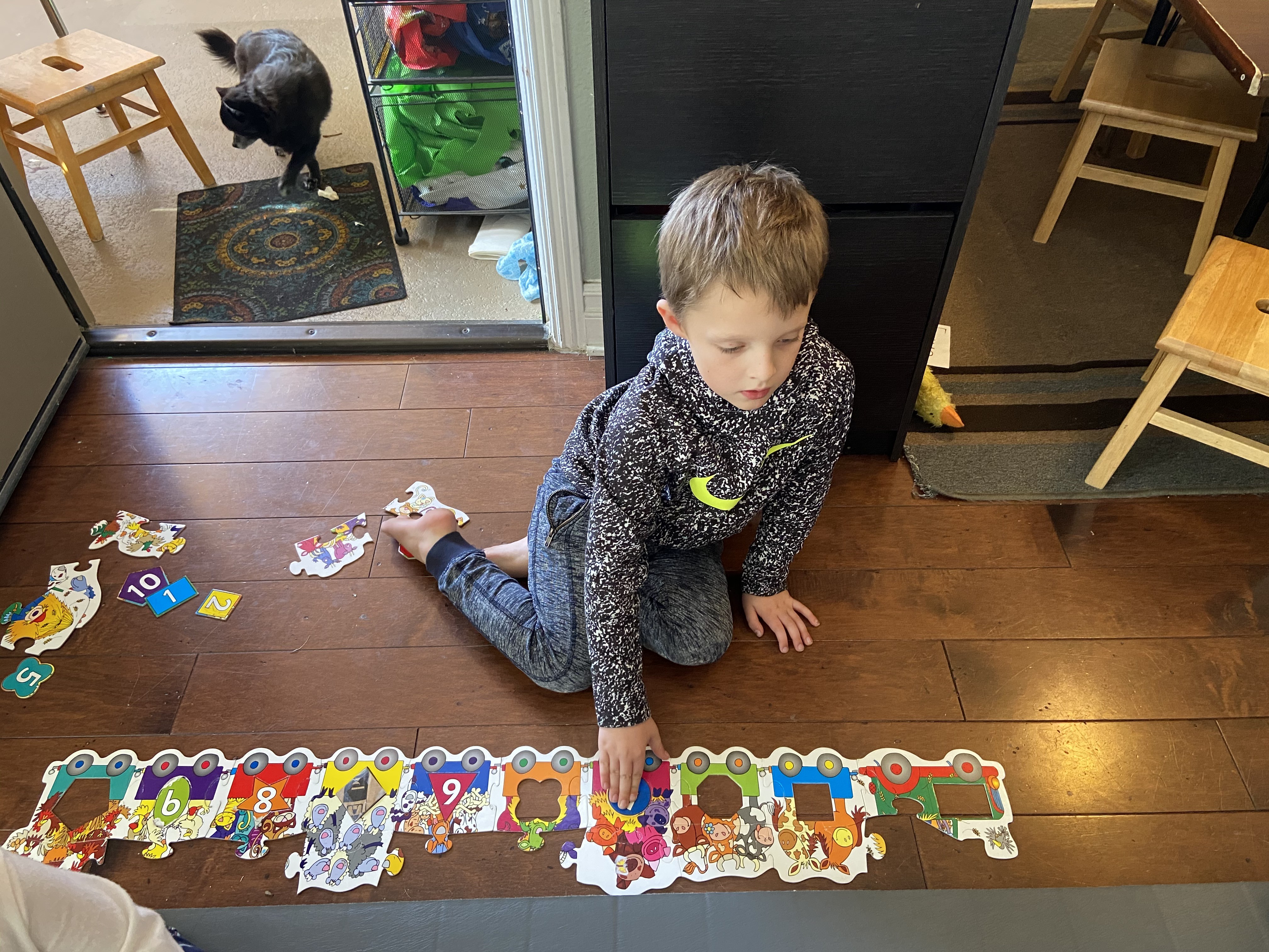 Boy playing with educational puzzle train, enhancing cognitive development at Ardenwald Preschool