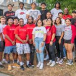 Group of smiling ECAP students standing outdoors on campus, representing the University of Arkansas Engineering Career Awareness Program, fostering community and support for underrepresented students in engineering.