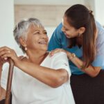 Smiling senior woman receiving home care assistance from a caregiver, illustrating the Alberta Health Self-Managed Care Program benefits through personalized care at home.