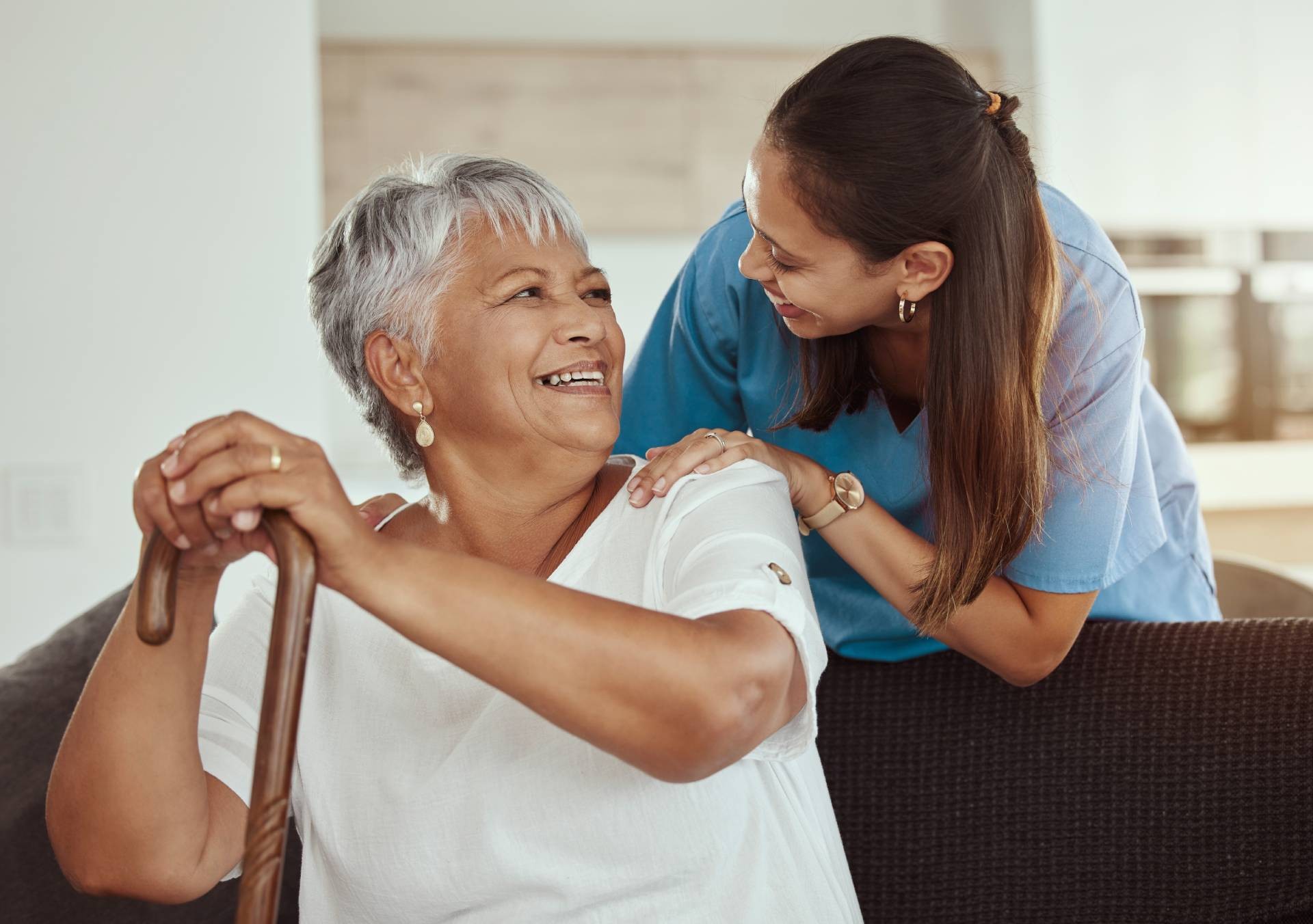 Smiling senior woman receiving home care assistance from a caregiver, illustrating the Alberta Health Self-Managed Care Program benefits through personalized care at home.